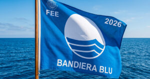 Bandiera Blu 2026 sventola su una spiaggia italiana, simbolo del riconoscimento FEE per qualità ambientale e servizi balneari.