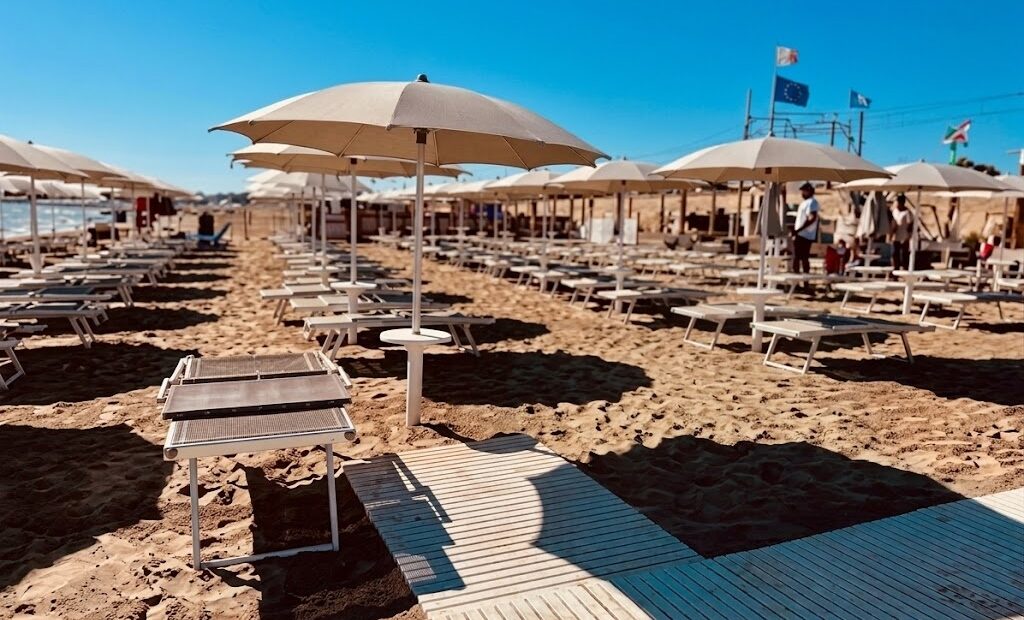 Una torretta di salvataggio sulla spiaggia di Pesaro con mare calmo sullo sfondo, rappresentativa della sicurezza balneare nelle Marche.