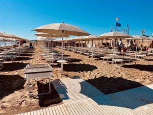 Una torretta di salvataggio sulla spiaggia di Pesaro con mare calmo sullo sfondo, rappresentativa della sicurezza balneare nelle Marche.