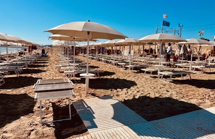 Una torretta di salvataggio sulla spiaggia di Pesaro con mare calmo sullo sfondo, rappresentativa della sicurezza balneare nelle Marche.
