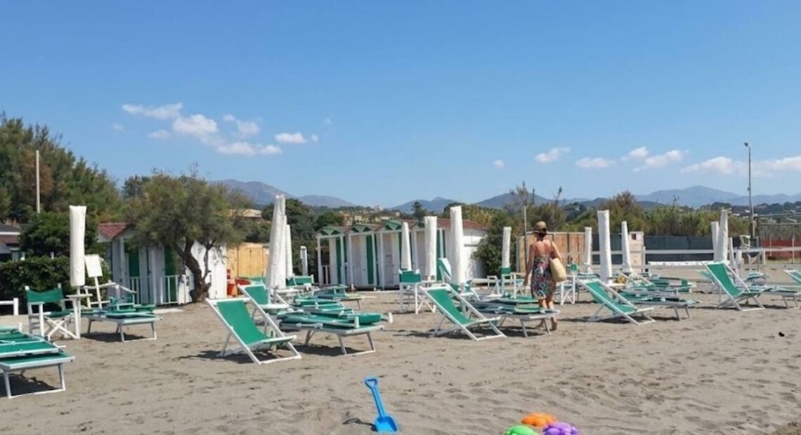 Spiaggia di Marinella con ombrelloni chiusi e attrezzature balneari da allestire