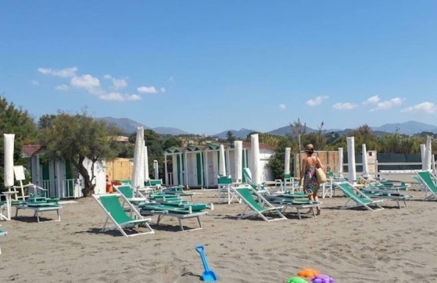 Spiaggia di Marinella con ombrelloni chiusi e attrezzature balneari da allestire