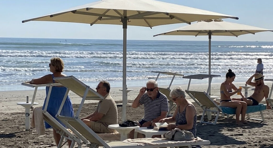 Turisti e bagnanti si rilassano sotto gli ombrelloni in uno stabilimento gestito dai balneari di Riccione.