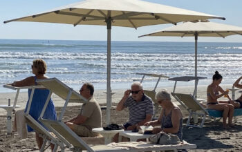 Turisti e bagnanti si rilassano sotto gli ombrelloni in uno stabilimento gestito dai balneari di Riccione.