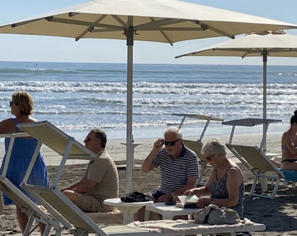 Turisti e bagnanti si rilassano sotto gli ombrelloni in uno stabilimento gestito dai balneari di Riccione.