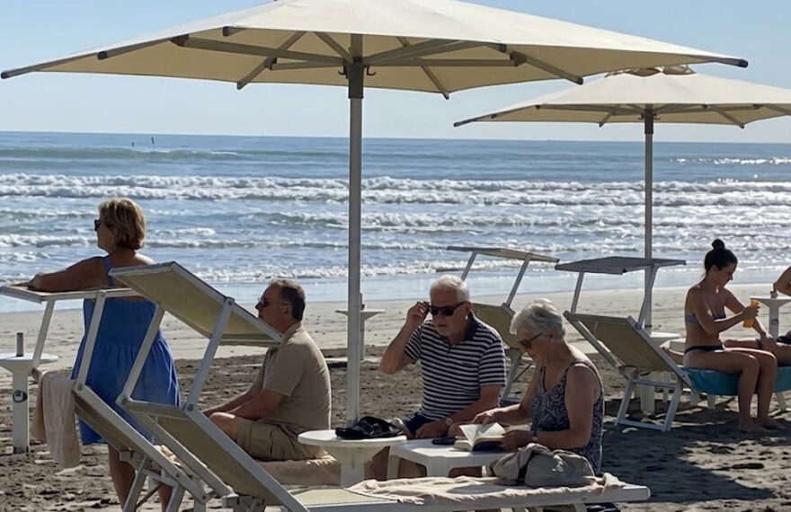 Turisti e bagnanti si rilassano sotto gli ombrelloni in uno stabilimento gestito dai balneari di Riccione.