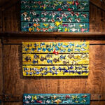 Interno di una cabina balneare in legno decorata con pannelli colorati pieni di pesciolini artistici in ceramica per la mostra Una Cabina d'Artista.