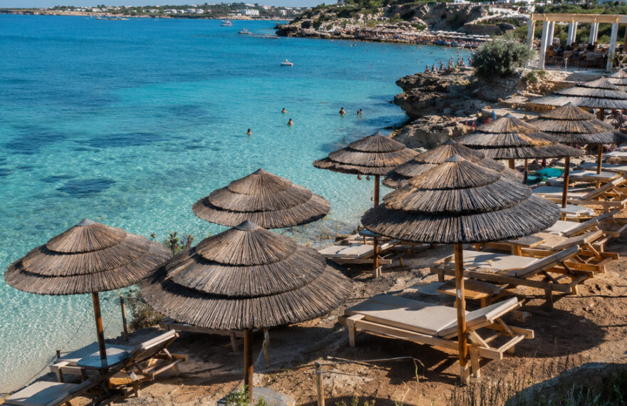 Ombrelloni in paglia e lettini esclusivi in uno stabilimento balneare nel Salento in riva al mare cristallino