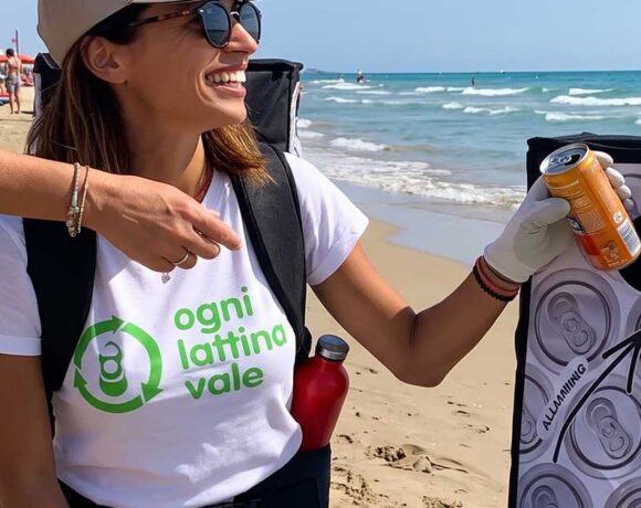 Due donne promuovono il riciclo delle lattine in alluminio su una spiaggia attrezzata