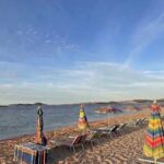 Fila di ombrelloni e lettini sulla sabbia in una spiaggia della Sardegna