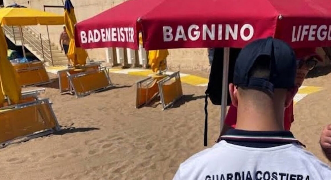 Un militare della Guardia Costiera di spalle durante i controlli sulle concessioni e le superfici degli stabilimenti balneari.