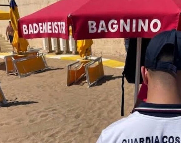 Un militare della Guardia Costiera di spalle durante i controlli sulle concessioni e le superfici degli stabilimenti balneari.