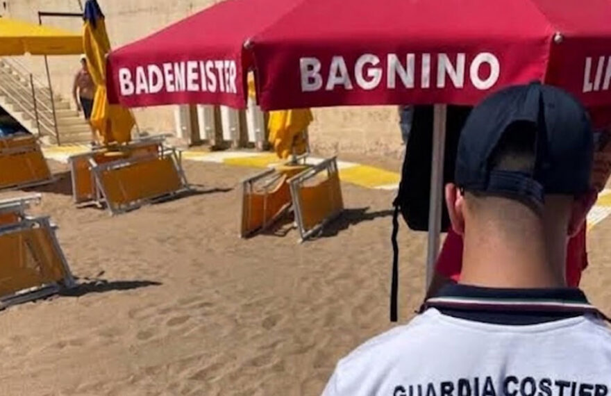 Un militare della Guardia Costiera di spalle durante i controlli sulle concessioni e le superfici degli stabilimenti balneari.