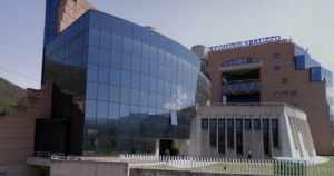 Facciata del Palazzo della Regione Abruzzo a L'Aquila, con insegna blu e struttura a tralicci gialli