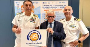 Antonio Capacchione presidente SIB con ufficiali della Guardia Costiera mostra il logo di Radio Balneare alla presentazione della campagna Annegamenti Zero.