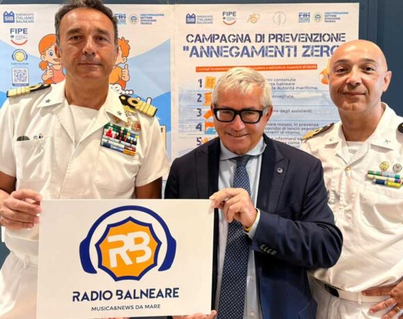 Antonio Capacchione presidente SIB con ufficiali della Guardia Costiera mostra il logo di Radio Balneare alla presentazione della campagna Annegamenti Zero.