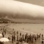 Spettacolare nuvola a rullo (Roll Cloud) cilindrica sulla spiaggia di Hendaye in Francia, con bagnanti che guardano il cielo.
