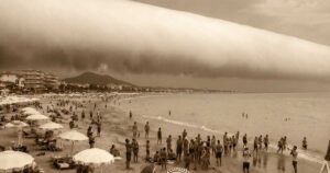 Spettacolare nuvola a rullo (Roll Cloud) cilindrica sulla spiaggia di Hendaye in Francia, con bagnanti che guardano il cielo.