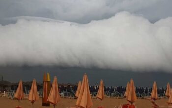 Imponente shelf cloud o nube a mensola sopra uno stabilimento balneare della costa marchigiana prima del temporale.