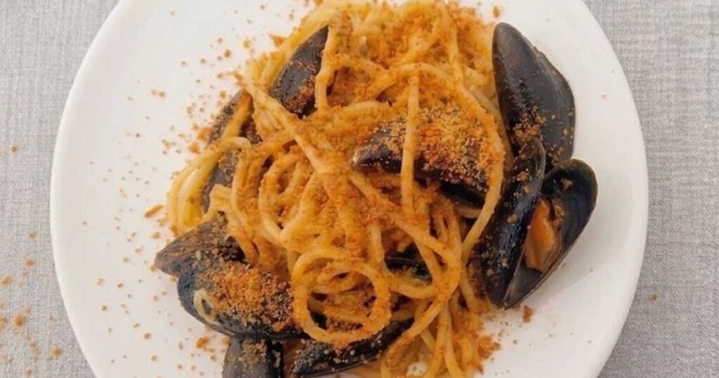 Piatto di spaghetti ai frutti di mare con cozze e mollica tostata tipici di Favignana