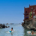 Bagnanti in mare alla spiaggia delle Monache a Posillipo senza servizi balneari attivi