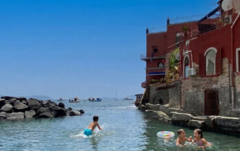 Bagnanti in mare alla spiaggia delle Monache a Posillipo senza servizi balneari attivi