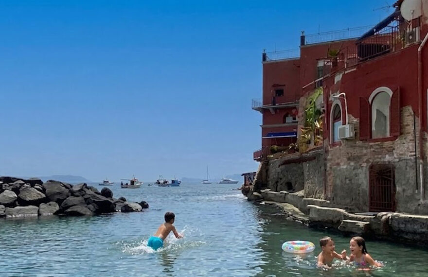 Bagnanti in mare alla spiaggia delle Monache a Posillipo senza servizi balneari attivi