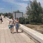 persone a passeggio sul waterfront di san girolamo bari