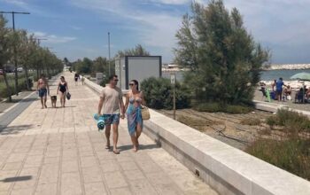 persone a passeggio sul waterfront di san girolamo bari