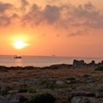Alba sul mare a Torre Incina lungo la costa tra Polignano e Monopoli con peschereccio al largo.