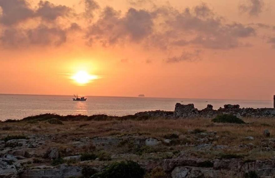 Alba sul mare a Torre Incina lungo la costa tra Polignano e Monopoli con peschereccio al largo.