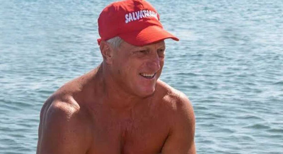 Un torretta di salvataggio con la boa rossa in spiaggia di fronte al mare mosso.