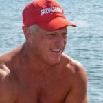 Un torretta di salvataggio con la boa rossa in spiaggia di fronte al mare mosso.