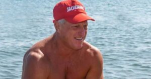 Un torretta di salvataggio con la boa rossa in spiaggia di fronte al mare mosso.