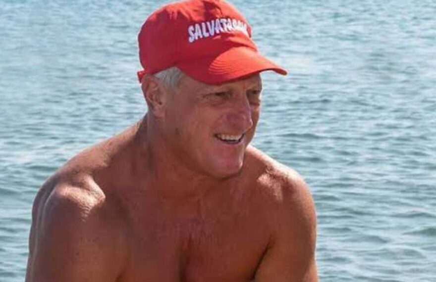 Un torretta di salvataggio con la boa rossa in spiaggia di fronte al mare mosso.