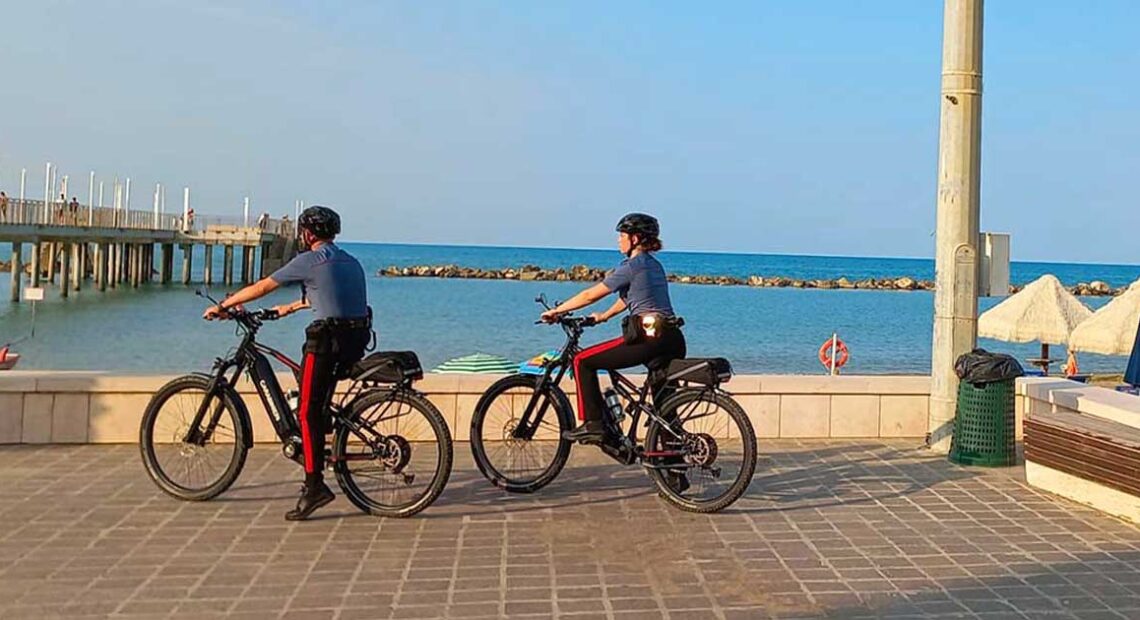 Due Carabinieri in bicicletta sul lungomare lungo la Costa dei Trabocchi.