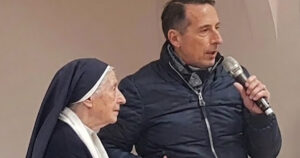 Suor Miranda al microfono con un relatore durante un incontro pubblico a Spotorno