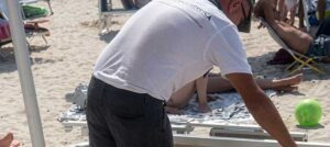 Rimozione e sequestro di lettini e ombrelloni abusivi sulla spiaggia libera di Ugento durante i controlli di Ferragosto.