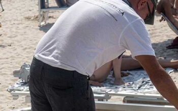 Rimozione e sequestro di lettini e ombrelloni abusivi sulla spiaggia libera di Ugento durante i controlli di Ferragosto.