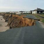 Strada costiera crollata a causa dell'intensa erosione e del cedimento della falesia sulla spiaggia.