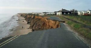 Strada costiera crollata a causa dell'intensa erosione e del cedimento della falesia sulla spiaggia.