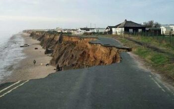 Strada costiera crollata a causa dell'intensa erosione e del cedimento della falesia sulla spiaggia.