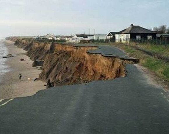 Strada costiera crollata a causa dell'intensa erosione e del cedimento della falesia sulla spiaggia.