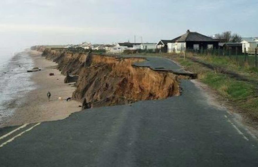 Strada costiera crollata a causa dell'intensa erosione e del cedimento della falesia sulla spiaggia.