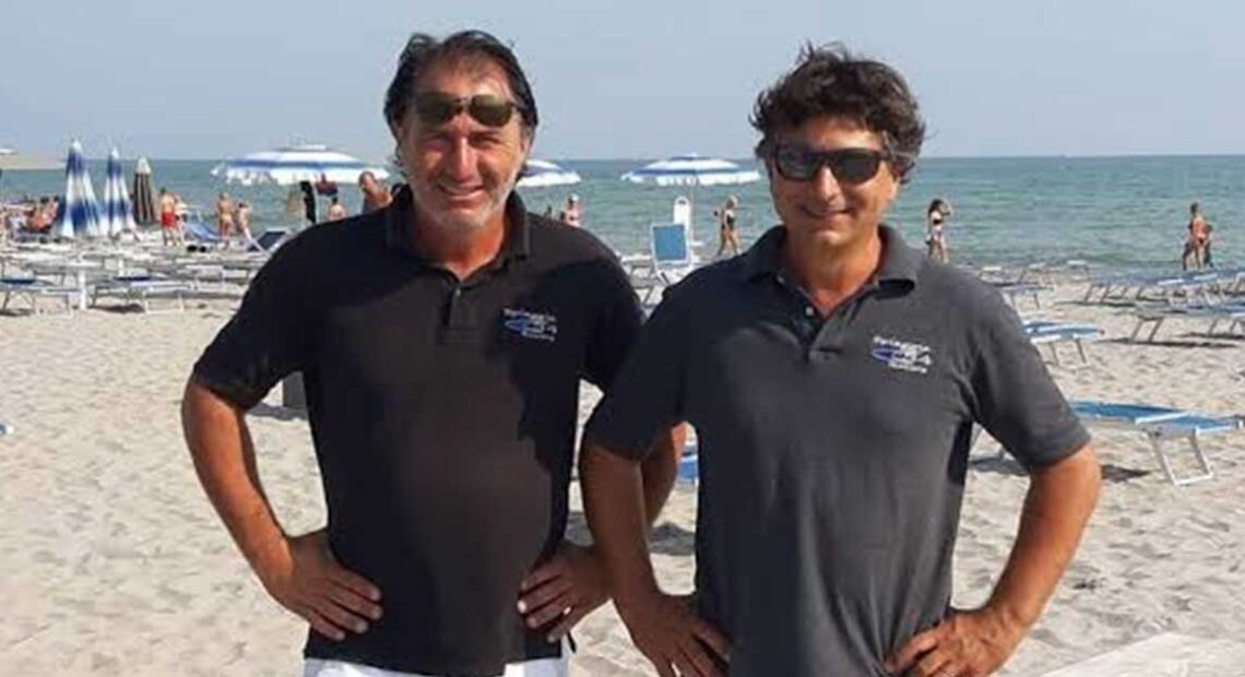 Gilberto e Cesare Fuzzi, gestori dei Bagni 54 Nino e Nando di Riccione, sorridenti in spiaggia.