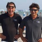Gilberto e Cesare Fuzzi, gestori dei Bagni 54 Nino e Nando di Riccione, sorridenti in spiaggia.