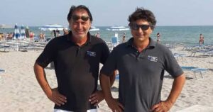 Gilberto e Cesare Fuzzi, gestori dei Bagni 54 Nino e Nando di Riccione, sorridenti in spiaggia.