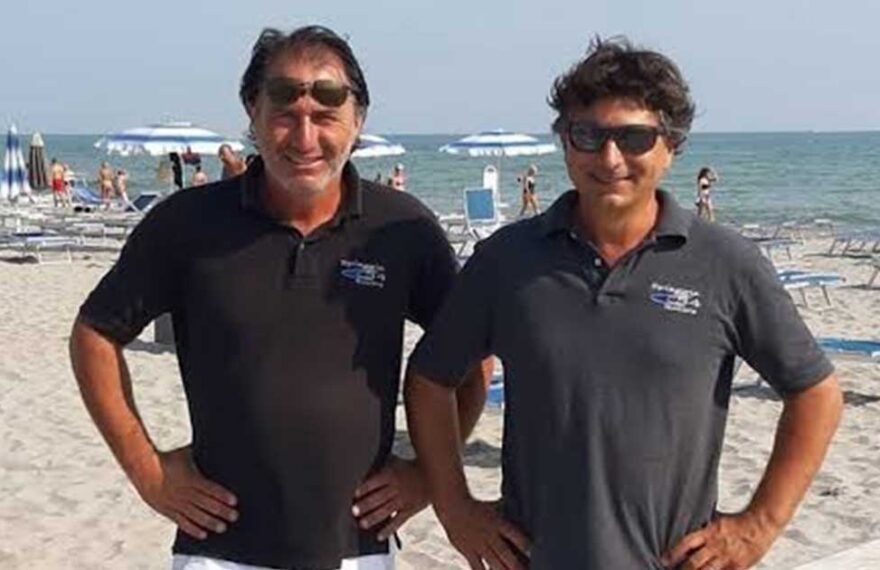 Gilberto e Cesare Fuzzi, gestori dei Bagni 54 Nino e Nando di Riccione, sorridenti in spiaggia.