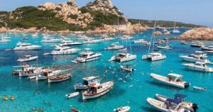 Numerose imbarcazioni da diporto e catamarani ormeggiati nelle acque trasparenti dell'arcipelago di La Maddalena