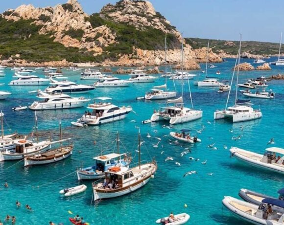Numerose imbarcazioni da diporto e catamarani ormeggiati nelle acque trasparenti dell'arcipelago di La Maddalena